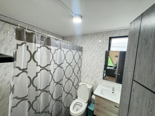a bathroom with a toilet and a shower curtain at Freedom home khaokho in Khao Kho