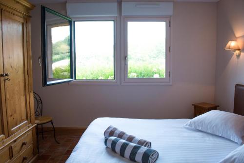 a bedroom with two beds and two windows at Holiday home Le clos du phare in Saint-Samson-de-la-Roque