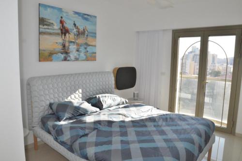 - une chambre avec un lit et une peinture murale dans l'établissement Luxury Jerusalem, à Jérusalem