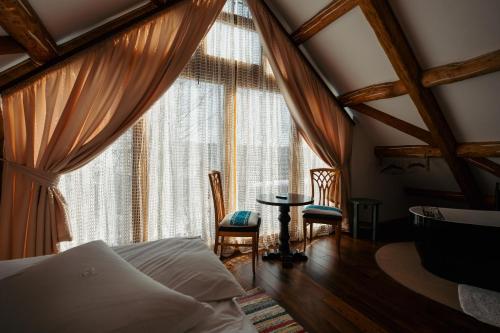 a bedroom with a bed and a table in front of a window at Cabana Huta Slavia in Şinteu