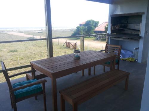 a wooden table and chairs with a view of a field at La Toscana 1 in Piriápolis