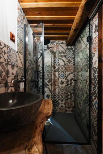 a bathroom with a sink and tiles on the wall at Cabana Huta Slavia in Şinteu