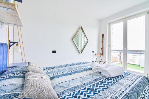 a bedroom with a bed with a blue and white blanket at Infinity Blue in Portovenere