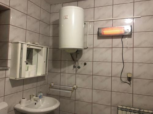 a bathroom with a sink and a light on the wall at Marko and Mila apartment in Prilep