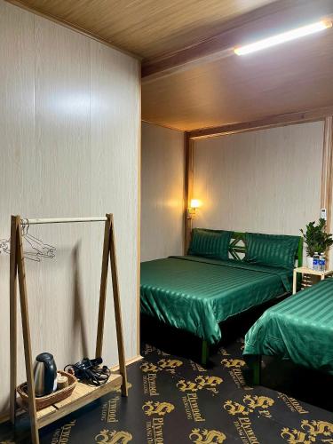 a room with two beds and a mirror at Danh Lam Homestay in Kon Rung (1)