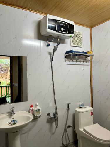 a bathroom with a toilet and a sink and a camera at Danh Lam Homestay in Kon Rung (1)