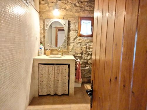ein Steinbadezimmer mit Waschbecken und Spiegel in der Unterkunft Moixons in Calonge de Segarra