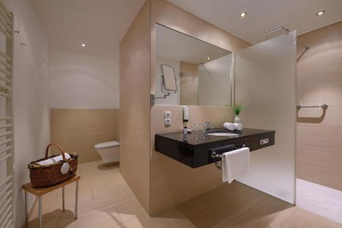 a bathroom with a sink and a mirror at IFA Graal-Müritz Hotel & Spa in Graal-Müritz