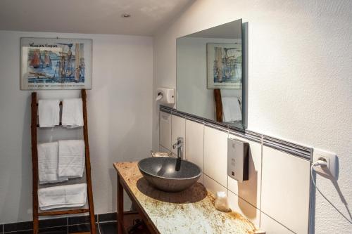 a bathroom with a sink and a mirror at Logis Auberge le centre poitou in Coulombiers