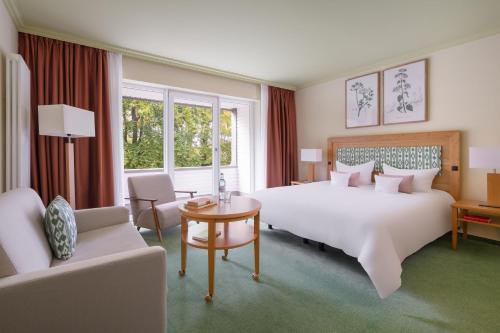 a hotel room with a large bed and a table at IFA Graal-Müritz Hotel & Spa in Graal-Müritz