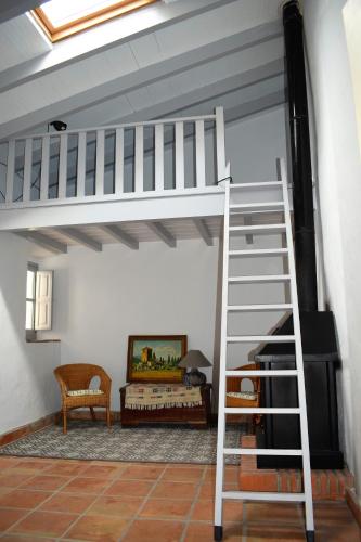 a loft bed with a ladder in a room at Cortijo Don Rodrigo in El Chorro