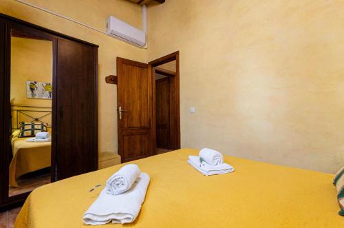 a room with a yellow bed with towels on it at YourHouse Padri de Inca in Inca
