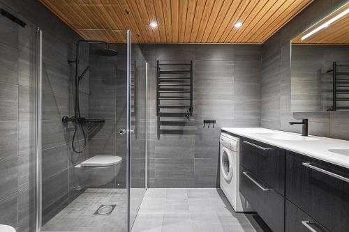 a bathroom with a shower and a washing machine at Fyri Tunet Hemsedal in Hemsedal