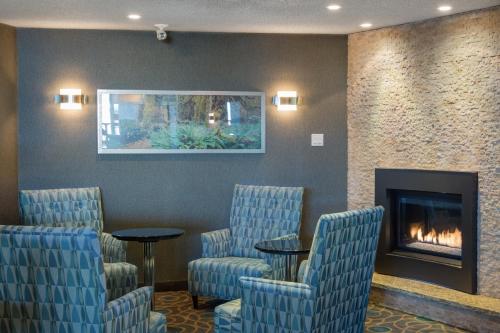 a waiting room with chairs and a fireplace at Ramada by Wyndham Kamloops in Kamloops