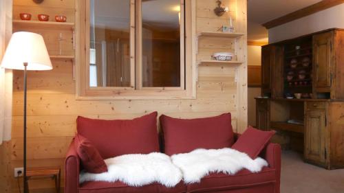 a red couch with white pillows in a room at Chalet Les Alpes in Val-d'Isère