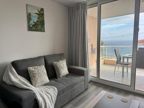 a living room with a couch and a view of the ocean at Seaview Suite in Caniço