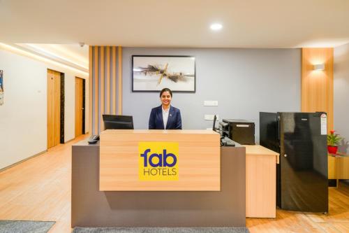 a woman standing behind a reception desk in an office at FabHotel White Ridge Chaitanyapuri in Hyderabad