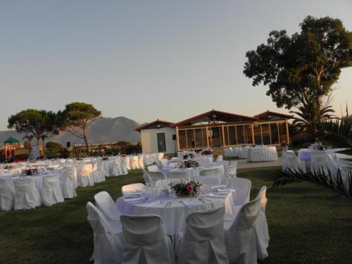 a group of tables with white chairs and tablesearcher at Irida Beach Resort Suites in Kyparissia