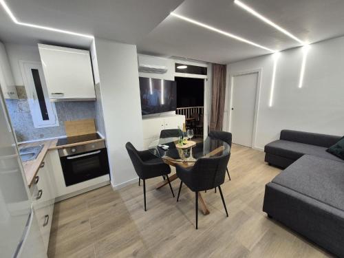 a kitchen and living room with a table and chairs at Vibre Canaris - Las Americas in Playa de las Americas
