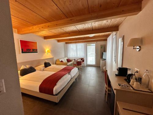 a bedroom with a large bed and a living room at Chalet Gafri -Boutique B&B - comfort and hospitality - near Interlaken in Wilderswil