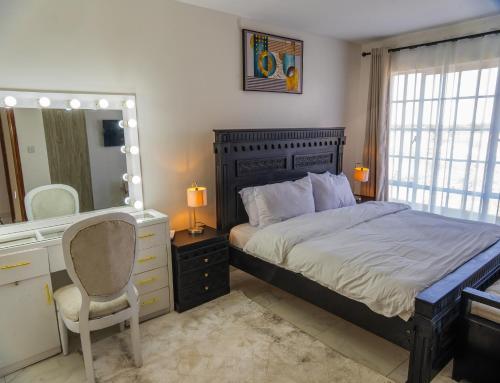 a bedroom with a bed and a desk and a mirror at Ngao #220 Swara Ranch in Nanyuki