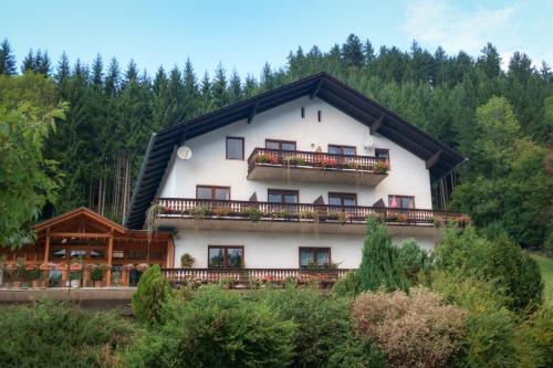 ein großes weißes Haus mit schwarzem Dach in der Unterkunft Alpenpension Gasthof in Ratten
