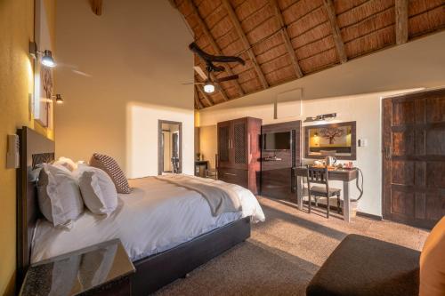 a bedroom with a bed and a desk in a room at Hannah Game Lodge in Ohrigstad