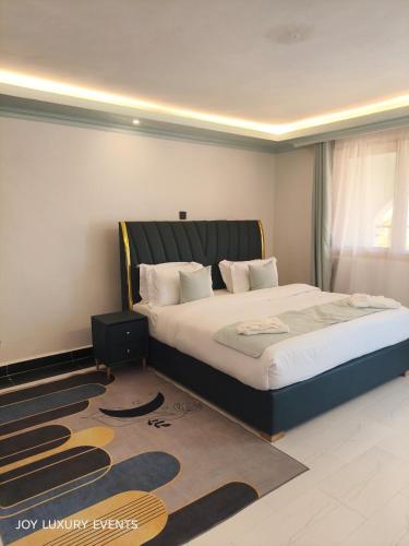 a bedroom with a large bed and a rug at The Africana Hotel in Isiolo