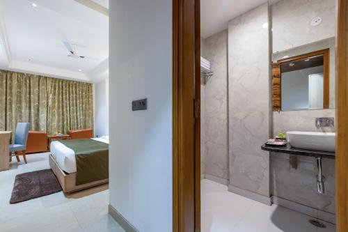 a bathroom with a bed and a sink in a room at Arch The Venus - Free Airport Pickup or Drop in New Delhi