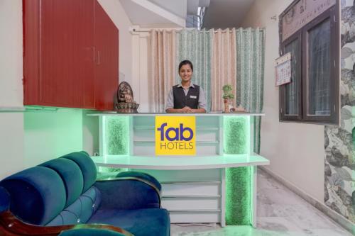 a woman standing behind a table in a room at FabHotel Tree view Residency in Lucknow