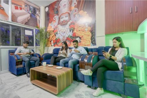 a group of people sitting on a couch in a waiting room at FabHotel Tree view Residency in Lucknow