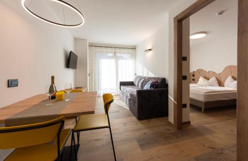 a dining room and living room with a table and chairs at Vacanze la Malga in Predazzo
