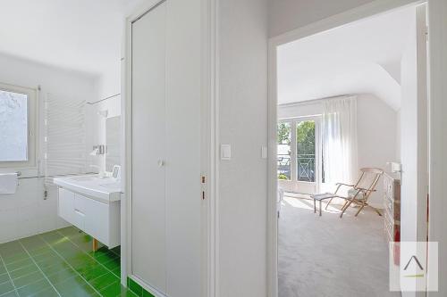 a white bathroom with a sink and a mirror at La Villa Moorings in Saint Malo