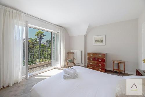 a bedroom with a bed and a large window at La Villa Moorings in Saint Malo