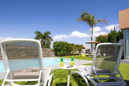 two chairs and a table next to a pool at Yellow Sunshine 8 by VillaGranCanaria in Salobre