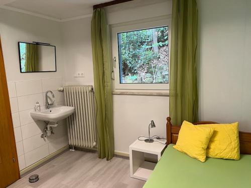 a bedroom with a bed and a sink and a window at Ferienhaus Südpfälzer Wald in Spirkelbach