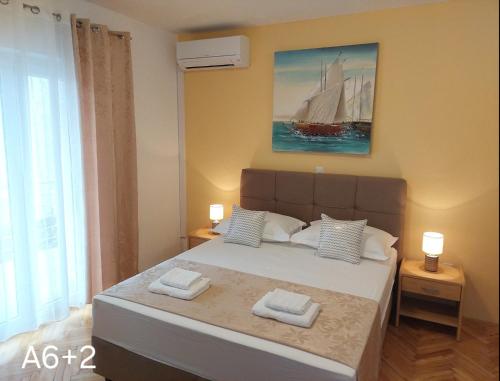 a bedroom with a large bed with two towels on it at Apartmani Dalibor, Stanići - Omiš in Stanići