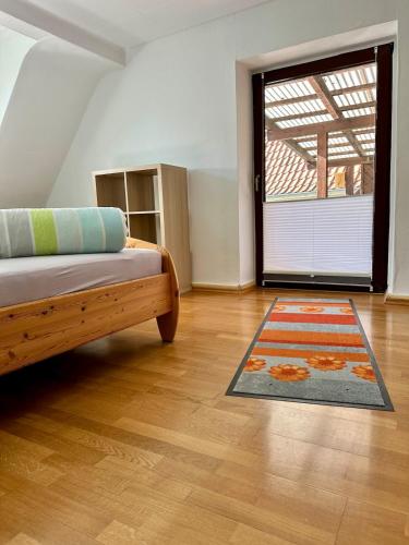 a room with a bed and a door with a rug at Ferienhaus Südpfälzer Wald in Spirkelbach