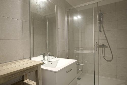 biała łazienka z umywalką i prysznicem w obiekcie Gold Beach Studio w mieście Tracy-sur-Mer