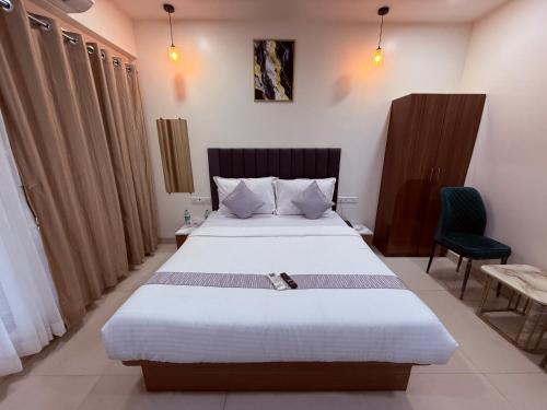 a bedroom with a large bed and a chair at Hotel Silver Leaf - Vile Parle East - Near Mumbai Airport in Mumbai