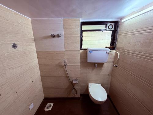 a bathroom with a toilet and a window at Hotel Silver Leaf - Vile Parle East - Near Mumbai Airport in Mumbai