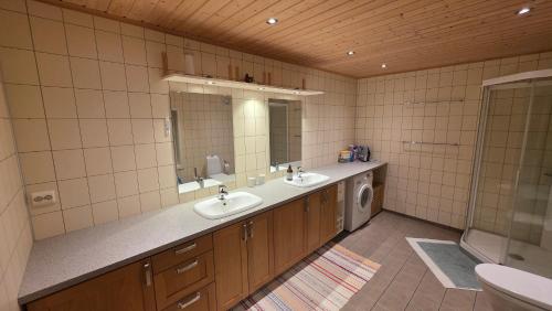 a bathroom with two sinks and a washing machine at Solodden, Authentic rorbu in Lofoten in Sennesvik