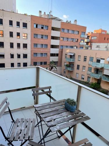 a balcony with a wooden bench and two chairs at NEW! Amazing 2 bedroom apartment in Rambla del Poblenou in Barcelona