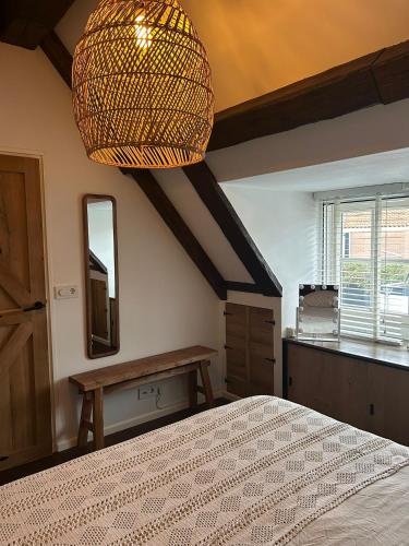 a bedroom with a large bed and a large chandelier at Urker Ussien in Urk