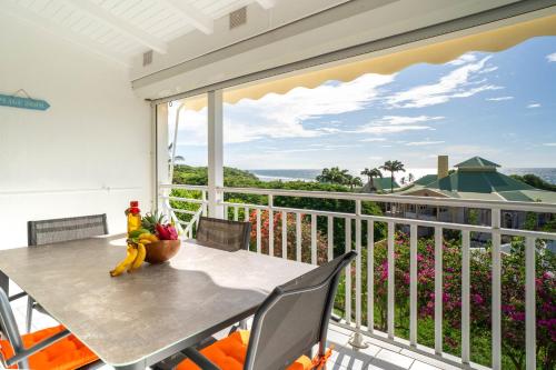 a table and chairs on a balcony with a view at Appartement Coconut in Saint-François