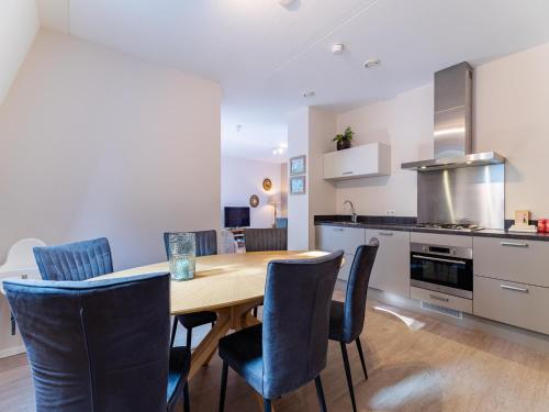 a kitchen and dining room with a wooden table and chairs at Holiday Home in Koudekerke near the Beach in Koudekerke