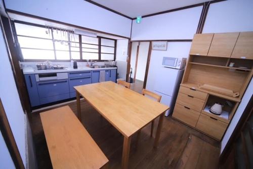 a kitchen with a wooden table and blue cabinets at 民泊 Knock Knock in Habikino