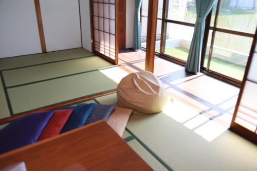 a living room with a couch and some windows at 民泊 Knock Knock in Habikino