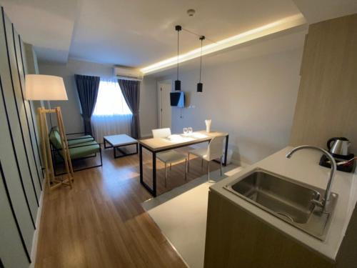 a kitchen with a sink and a table at GREENHILLS RESORT Si Racha in Ban Nong Wa
