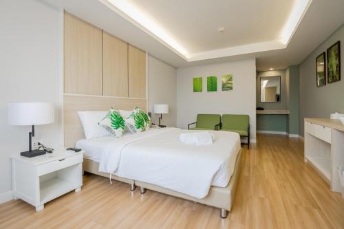 a large white bedroom with a large bed and a desk at GREENHILLS RESORT Si Racha in Ban Nong Wa
